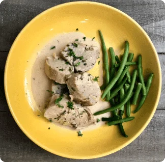 A yellow bowl filled with meat and green beans