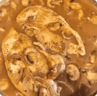 A pan filled with chicken and mushrooms covered in gravy